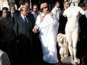 Libyan leader Muammar Qaddafi holding Silvio Berlusconi's hand as he speaks next to a Roman statue of the goddess Venus, Benghazi, Libya, August 30, 2008