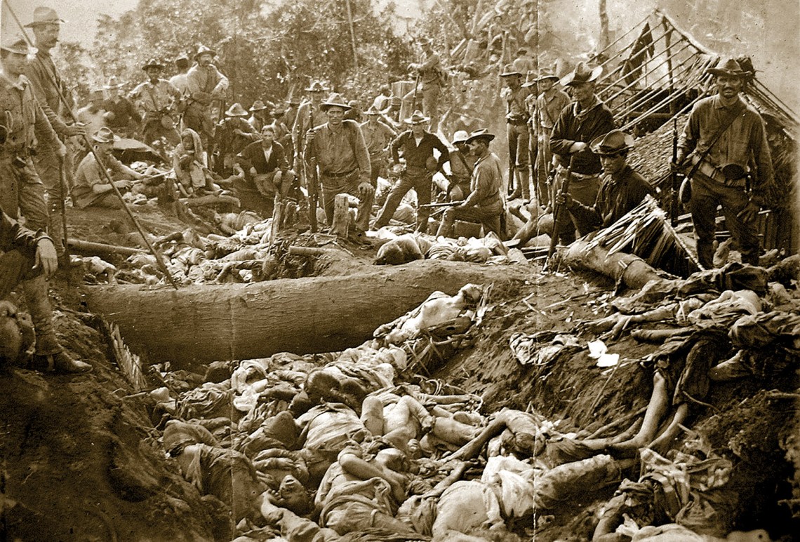 US soldiers posing with the bodies of Moro people after the massacre of Bud Dajo, Jolo Island, Philippines